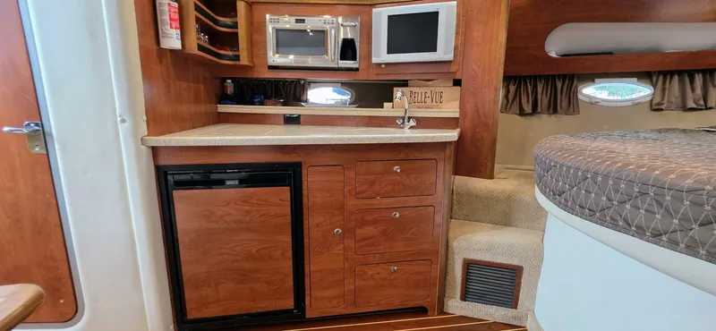 Yacht Photos Pics 2007 Rinker 350 Express cabin interior with kitchenette, microwave, and cozy sleeping area.