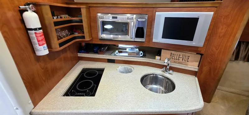  Yacht Photos Pics 2007 Rinker 350 Express yacht kitchen with stove, sink, microwave, and TV.