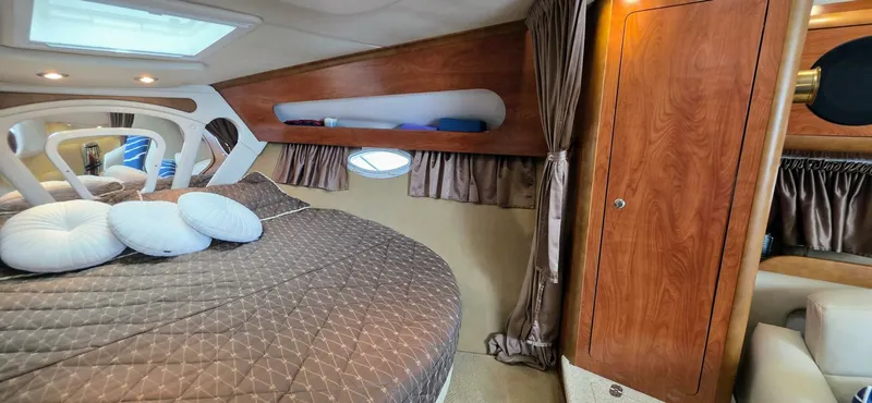  Yacht Photos Pics Luxurious cabin interior of a 2007 Rinker 350 Express yacht with cozy bedding and wood accents.