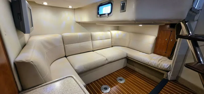  Yacht Photos Pics 2007 Rinker 350 Express cabin interior with beige leather seating and wood flooring.