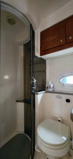  Yacht Photos Pics 2007 Rinker 350 Express bathroom with shower, toilet, and wooden cabinets.