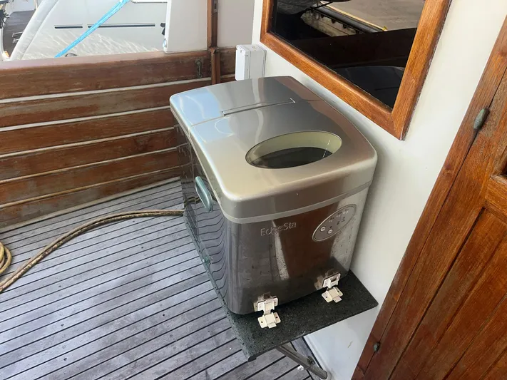 Anna Marie Yacht Photos Pics Portable washing machine on 1987 Kadey-Krogen 42 yacht deck, wooden paneling background.