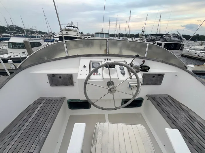 Anna Marie Yacht Photos Pics Helm of 1987 Kadey-Krogen 42 boat with steering wheel and controls, docked at marina.