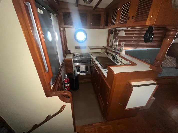 Anna Marie Yacht Photos Pics 1987 Kadey-Krogen 42 yacht kitchen with wooden cabinetry and porthole window.