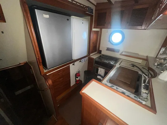 Anna Marie Yacht Photos Pics 1987 Kadey-Krogen 42 yacht kitchen with stove, fridge, and wooden cabinetry.
