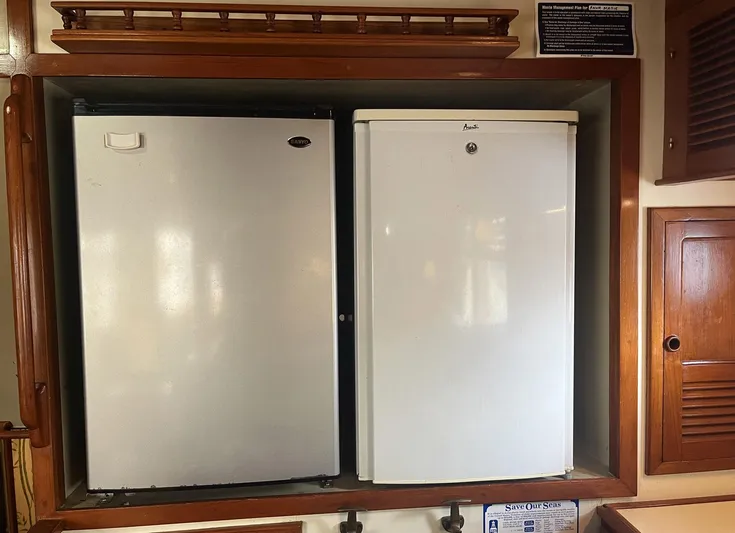 Anna Marie Yacht Photos Pics Dual refrigerators in a 1987 Kadey-Krogen 42 yacht kitchen, featuring wooden cabinetry.