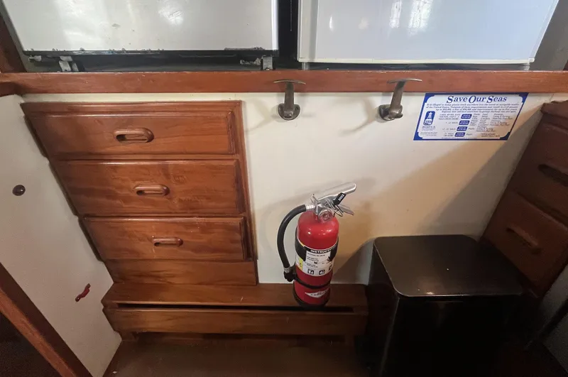 Anna Marie Yacht Photos Pics Interior of 1987 Kadey-Krogen 42 with wooden drawers, fire extinguisher, and informational sign.