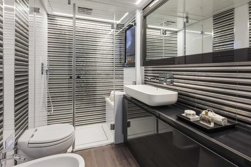  Yacht Photos Pics Luxurious bathroom in 2018 Pershing 7X yacht with modern fixtures and striped design.