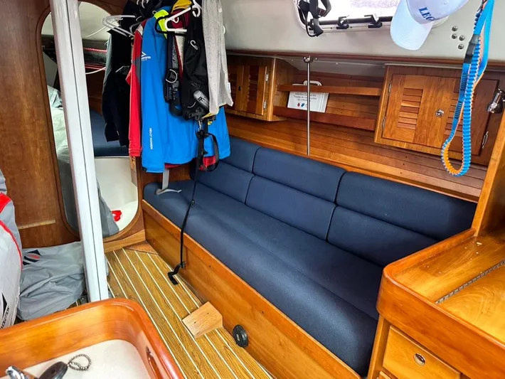 "legacy" Yacht Photos Pics Interior of 2006 J Boats J/109 sailboat with blue seating and wooden cabinetry.