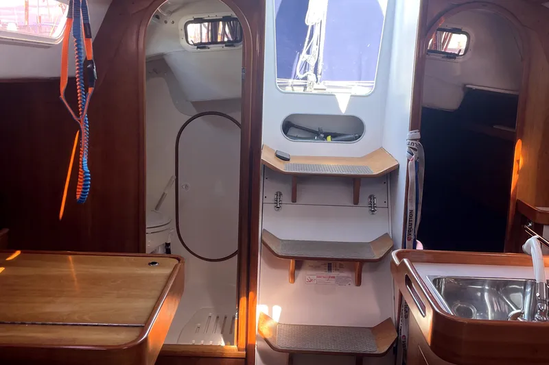 "legacy" Yacht Photos Pics Interior of 2006 J Boats J/109 sailboat, featuring wooden cabinetry and compact kitchen area.