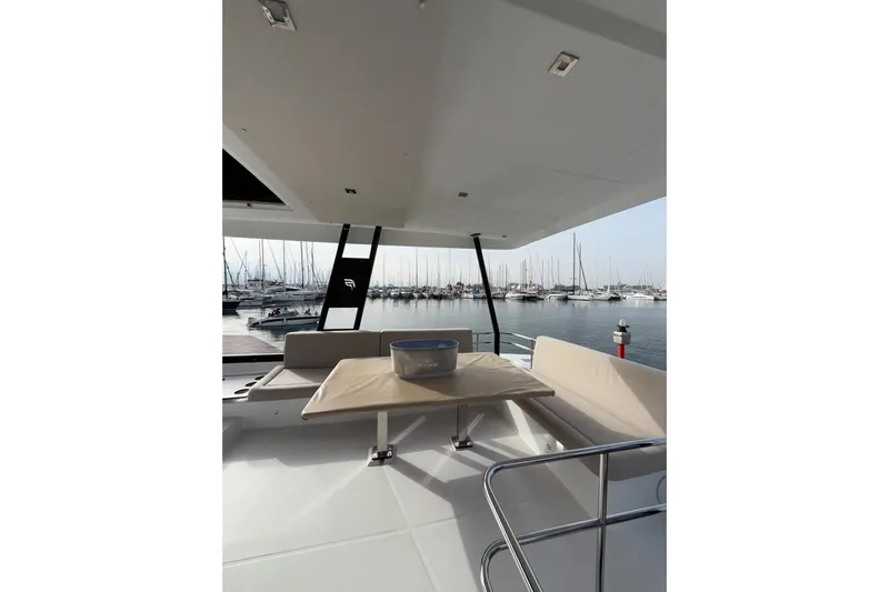  Yacht Photos Pics 2025 Fountaine Pajot MY6 yacht interior with marina view, featuring seating and table.