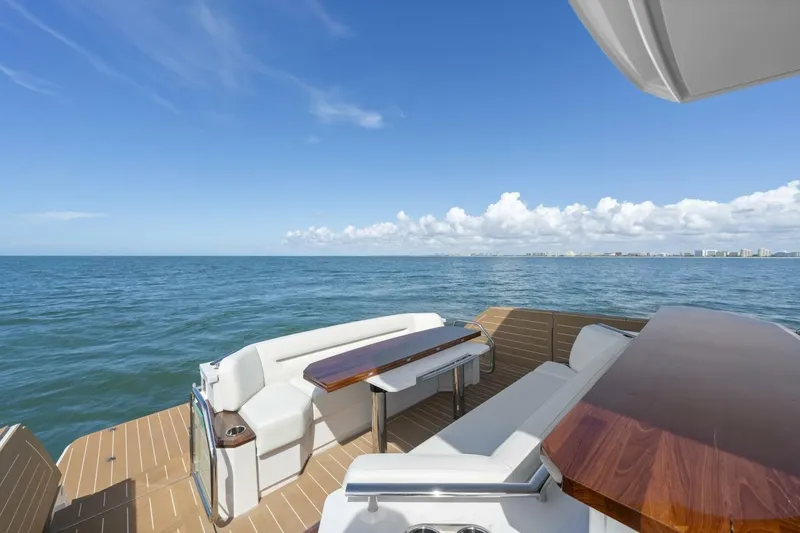 Tranquil Moments II Yacht Photos Pics 2023 Tiara Yachts EX 60 deck with ocean view, featuring elegant seating and wooden tables.