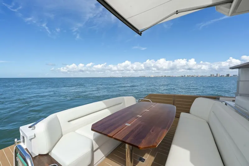 Tranquil Moments II Yacht Photos Pics 2023 Tiara Yachts EX 60 deck with ocean view, featuring elegant seating and wooden table.
