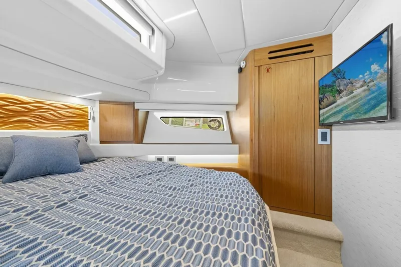 Tranquil Moments II Yacht Photos Pics Luxurious cabin interior of 2023 Tiara Yachts EX 60 with modern design and cozy bedding.