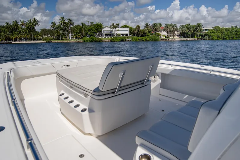  Yacht Photos Pics 2019 Invincible 37 Catamaran interior with seating, on calm water, palm trees in background.