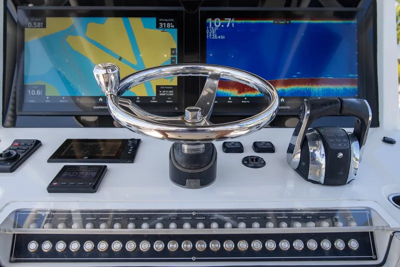  Yacht Photos Pics Control panel of 2019 Invincible 37 Catamaran with navigation screens and steering wheel.