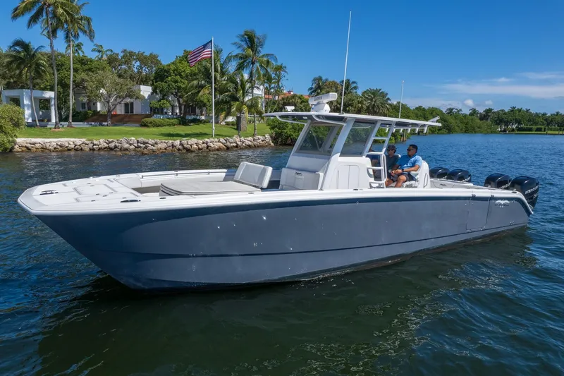  Yacht Photos Pics 2019 Invincible 37 Catamaran cruising on a sunny day near a lush shoreline.