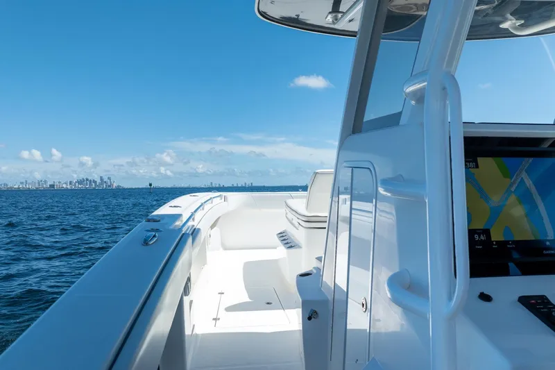  Yacht Photos Pics 2019 Invincible 37 Catamaran cruising on open water with city skyline in background.