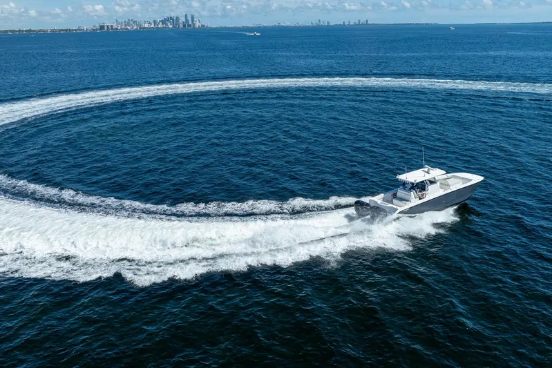  Yacht Photos Pics 2019 Invincible 37 Catamaran making a circular wake on open blue water.