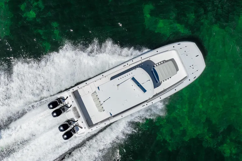  Yacht Photos Pics Aerial view of 2019 Invincible 37 Catamaran cruising on clear green water.