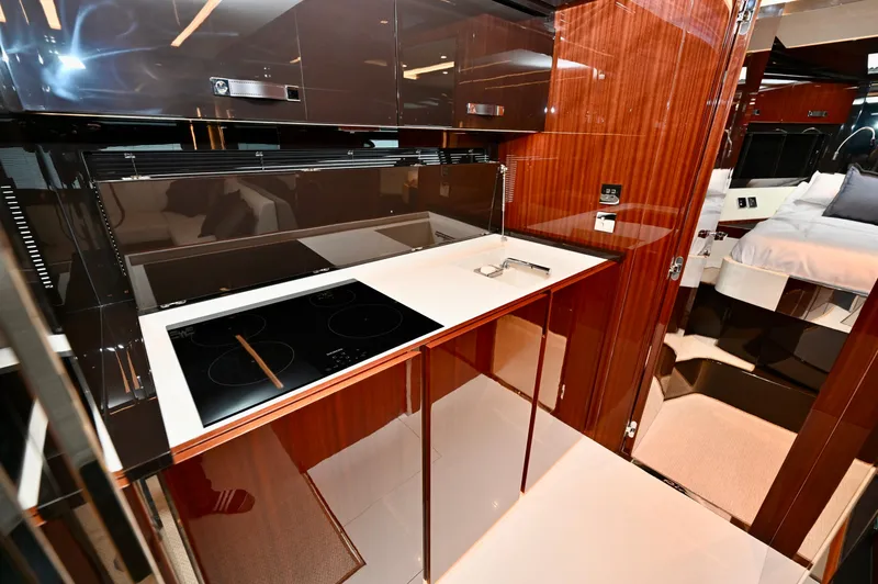 Maximus Yacht Photos Pics Modern kitchen area in 2023 Riva 56 Rivale yacht with sleek cabinetry and induction cooktop.