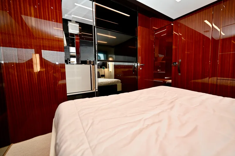 Maximus Yacht Photos Pics Luxurious bedroom interior of 2023 Riva 56 Rivale yacht with glossy wood finishes.