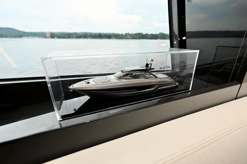 Maximus Yacht Photos Pics Model of 2023 Riva 56 Rivale yacht displayed in a glass case by a window.