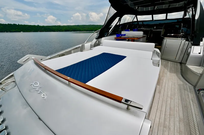 Maximus Yacht Photos Pics 2023 Riva 56 Rivale luxury yacht with spacious deck and sunbed on a serene lake.