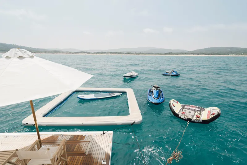 Centurion Yacht Photos Pics Luxury yacht deck with water toys, paddleboard, and jet skis on a sunny day.