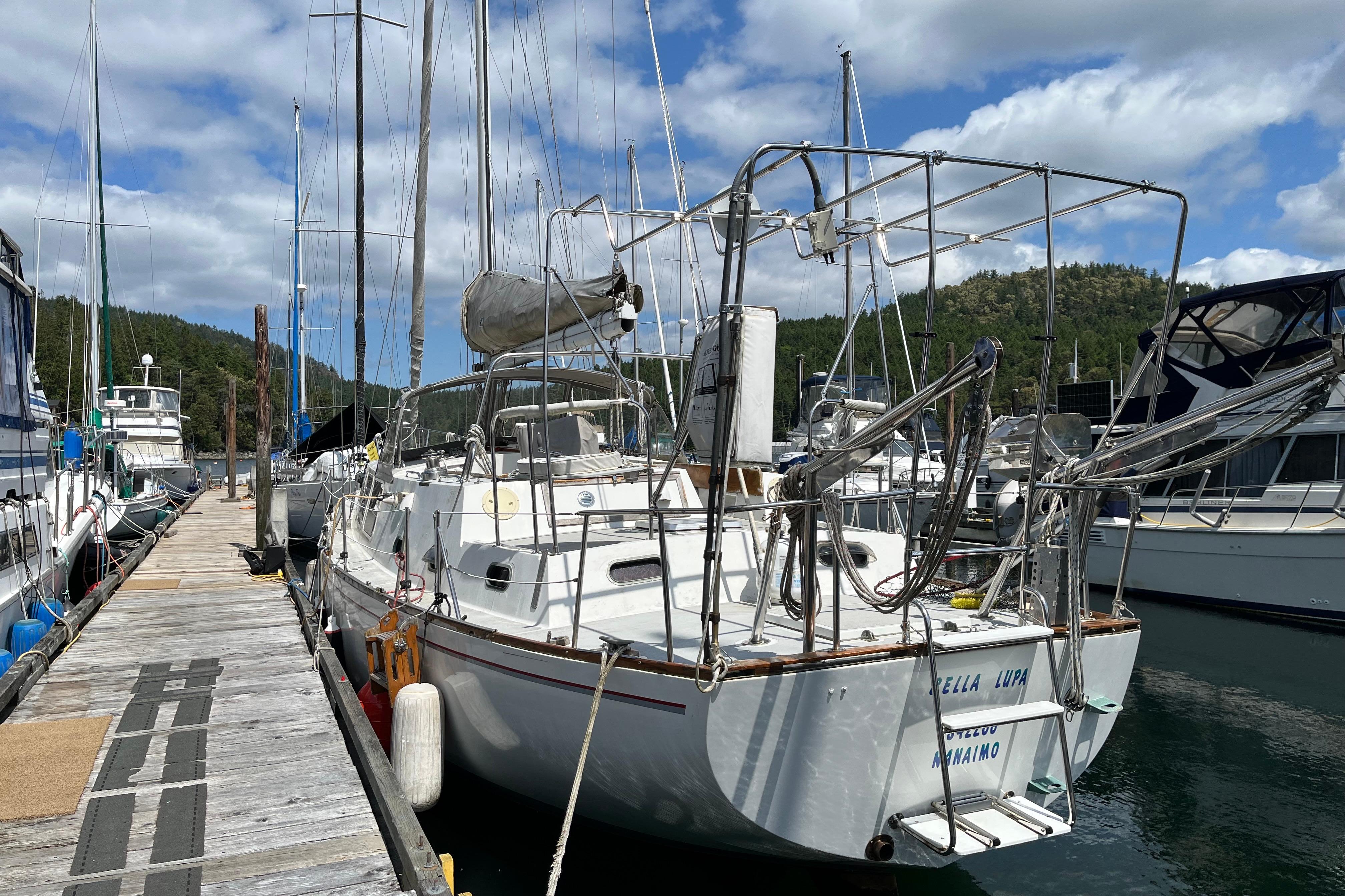1972 CAL 2-46 sailboat docked at marina, surrounded by other boats, under a partly cloudy sky.