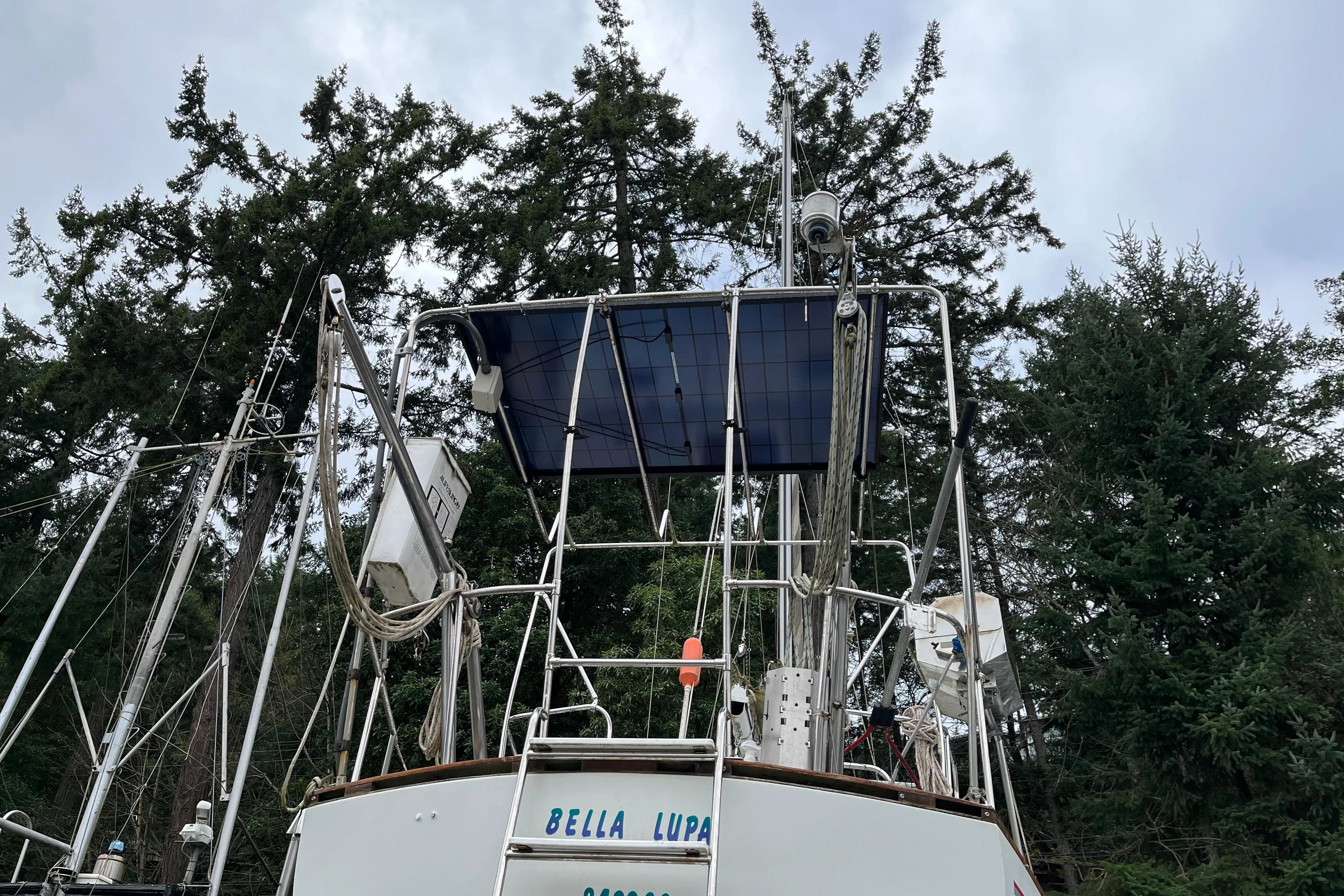 Sailboat with solar panels and equipment, surrounded by tall trees, CAL 2-46 model, 1972.