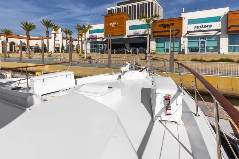  Yacht Photos Pics 1981 Hatteras Extended Deckhouse yacht docked near modern shopping center.