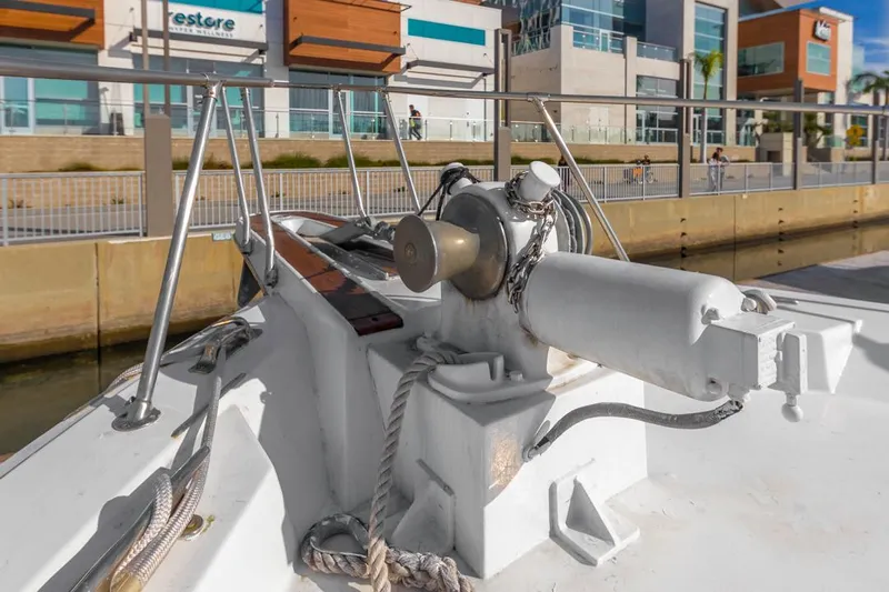  Yacht Photos Pics 1981 Hatteras Extended Deckhouse yacht deck with winch and ropes, docked near modern buildings.