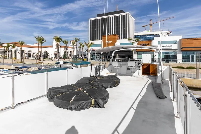  Yacht Photos Pics 1981 Hatteras Extended Deckhouse yacht docked at a marina with modern buildings in the background.
