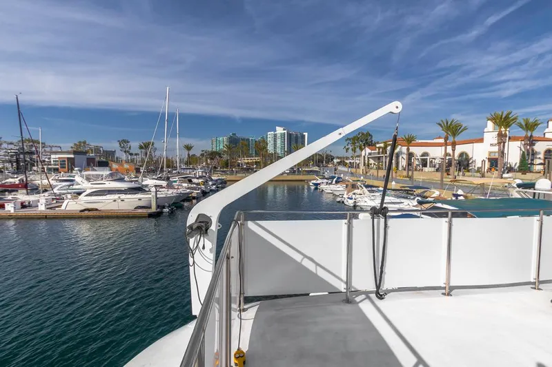  Yacht Photos Pics 1981 Hatteras Extended Deckhouse yacht docked in a sunny marina with palm trees.