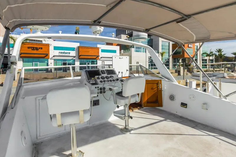  Yacht Photos Pics 1981 Hatteras Extended Deckhouse yacht helm with modern controls, docked near shops.