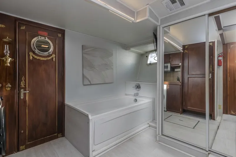  Yacht Photos Pics Luxurious bathroom in 1981 Hatteras Extended Deckhouse yacht with wood accents and mirrored closet.