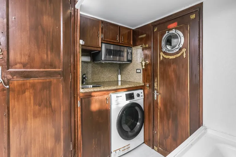  Yacht Photos Pics 1981 Hatteras Extended Deckhouse laundry area with wood cabinets and porthole door.