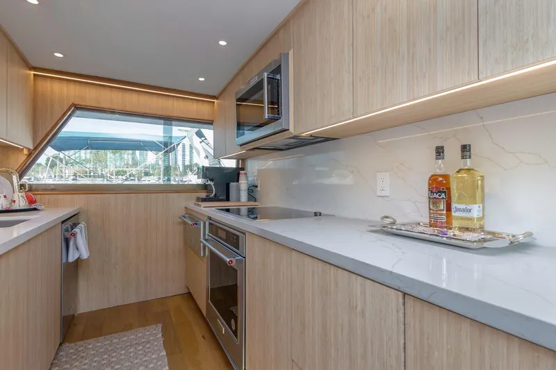  Yacht Photos Pics Modern kitchen interior on 1981 Hatteras Extended Deckhouse yacht, featuring sleek wood cabinetry and appliances.