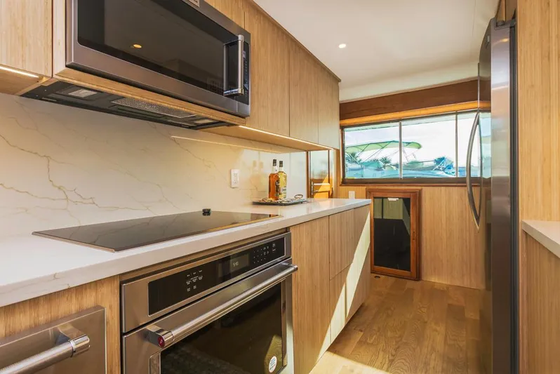  Yacht Photos Pics Modern kitchen in 1981 Hatteras Extended Deckhouse yacht with sleek appliances and wood finishes.