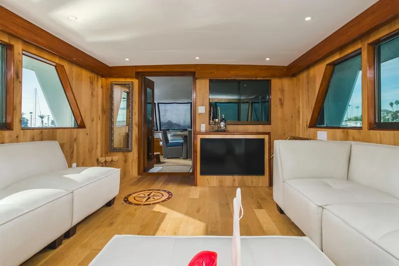  Yacht Photos Pics Luxurious 1981 Hatteras Extended Deckhouse interior with white sofas and wood paneling.