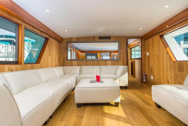  Yacht Photos Pics Luxurious 1981 Hatteras Extended Deckhouse interior with white sofas and wooden accents.