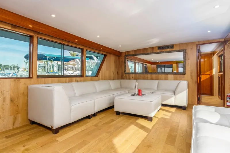  Yacht Photos Pics Luxurious 1981 Hatteras Extended Deckhouse interior with white leather seating and wood accents.