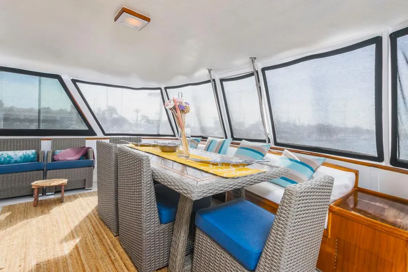  Yacht Photos Pics Spacious interior of 1981 Hatteras Extended Deckhouse with wicker furniture and large windows.