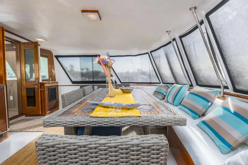  Yacht Photos Pics Interior of 1981 Hatteras Extended Deckhouse with wicker furniture and striped cushions.