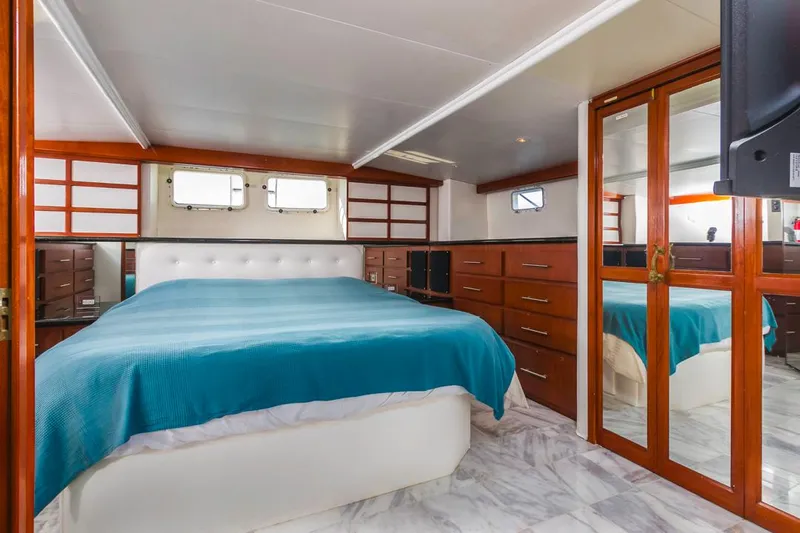  Yacht Photos Pics Luxurious bedroom in 1981 Hatteras Extended Deckhouse yacht with modern decor and ample storage.