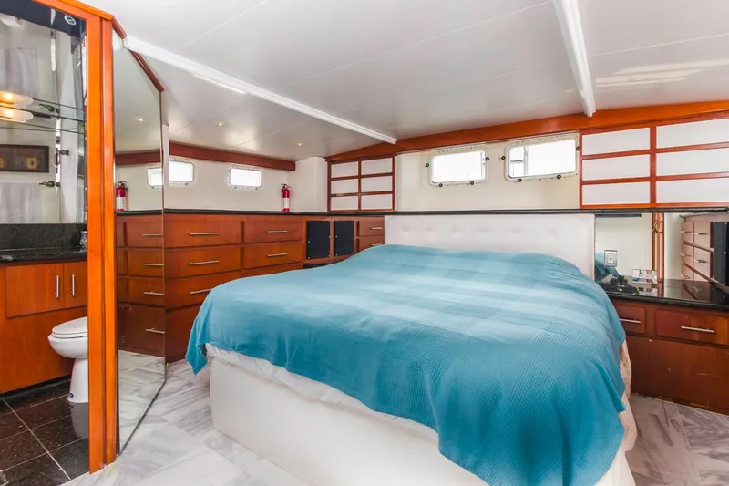  Yacht Photos Pics Luxurious 1981 Hatteras Extended Deckhouse bedroom with modern decor and ample storage.