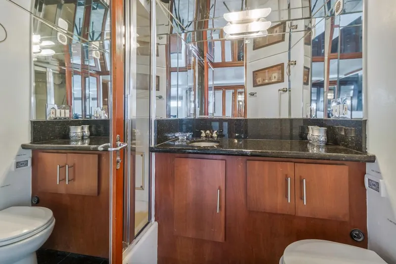  Yacht Photos Pics Luxurious bathroom in 1981 Hatteras Extended Deckhouse yacht with mirrored walls and wooden cabinetry.