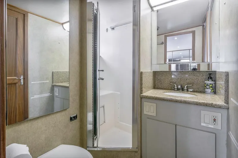  Yacht Photos Pics 1981 Hatteras Extended Deckhouse bathroom with shower, sink, and mirror.