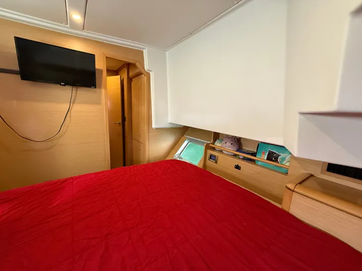Carolina Breeze Yacht Photos Pics Interior cabin of 2009 Lagoon 500 yacht with red bedding and wall-mounted TV.